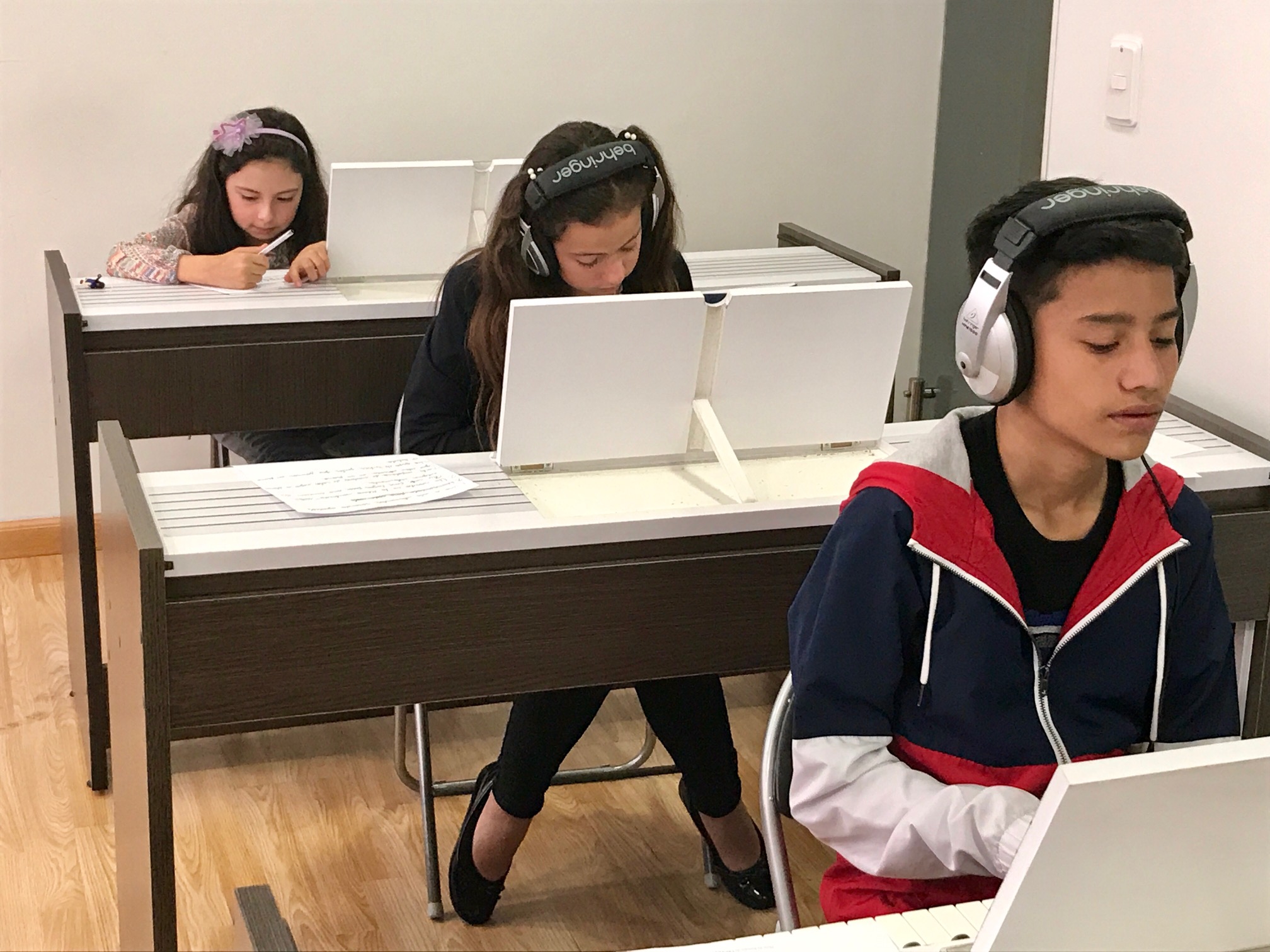 niños y jóvenes frente a teclados estudiando en academia musical TUTEMPO