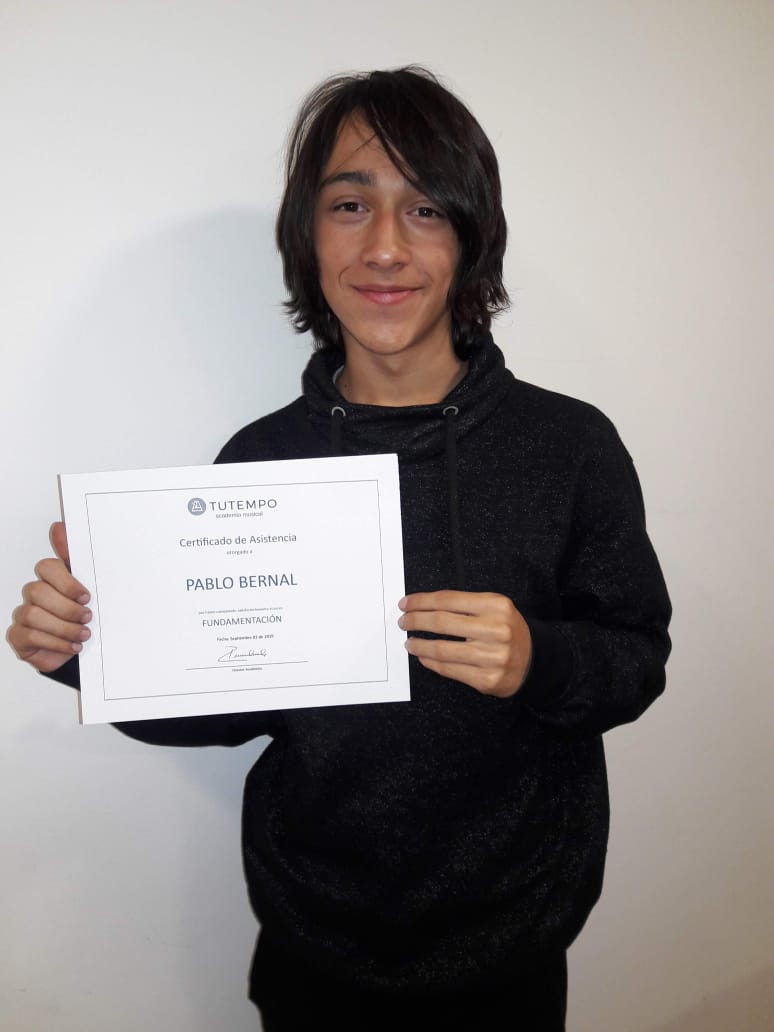 Pablo, estudiante recibiendo certificado en TUTEMPO academia musical