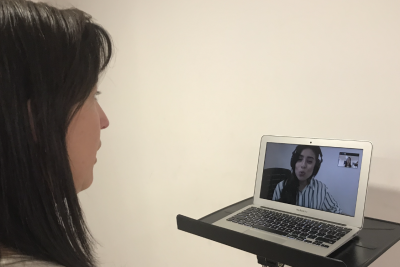 Clase canto online mujer frente a computador recibiendo clases de canto online