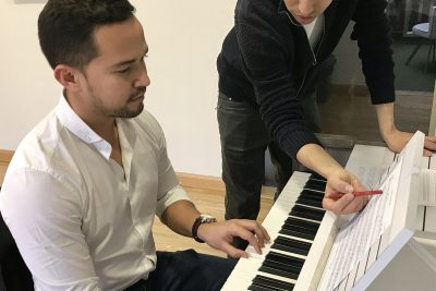 hombre recibiendo clase de piano en academia musical TUTEMPO